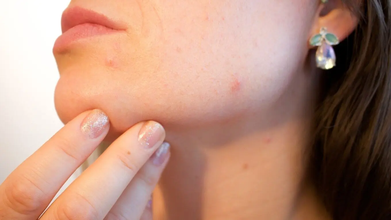 A close up of a woman touching her chin